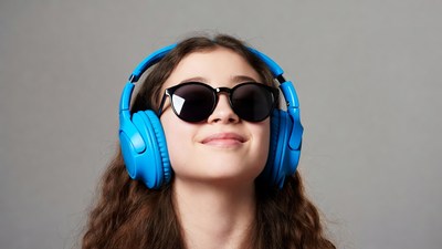 Girl wearing blue headphones and sunglasses