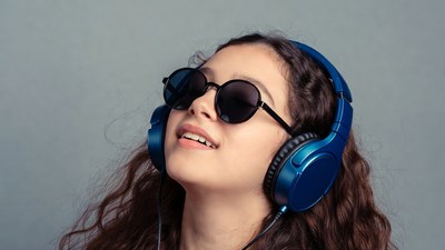 Girl wearing blue headphones and sunglasses