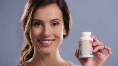 Smiling woman holding supplement bottle