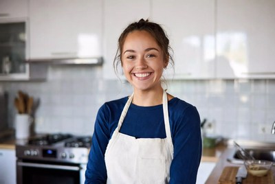 Smiling woman in apron in kitchen