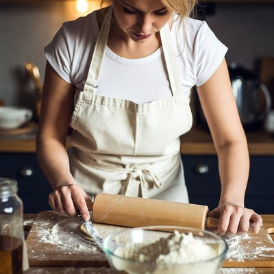 Blonde woman rolling dough in kitchen