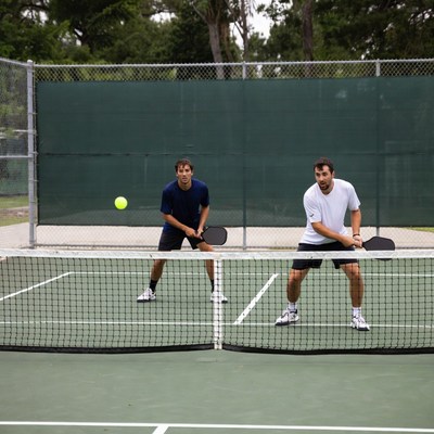 Two men playing tennis outdoors