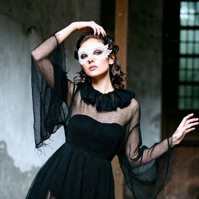 Woman in lace mask wearing black dress