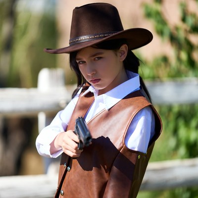 Girl in cowboy hat holding gun
