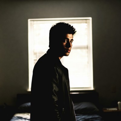 Young man in leather jacket by window