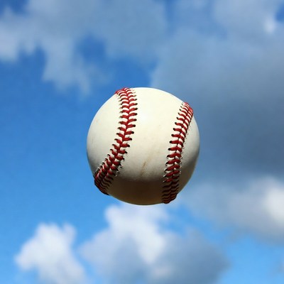Baseball floating in blue sky