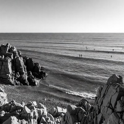 Surfers on waves near rocky beach