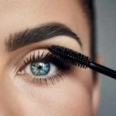 Woman applying mascara close-up