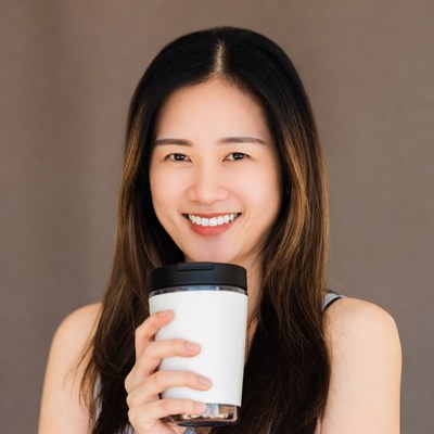Asian woman holding white tumbler