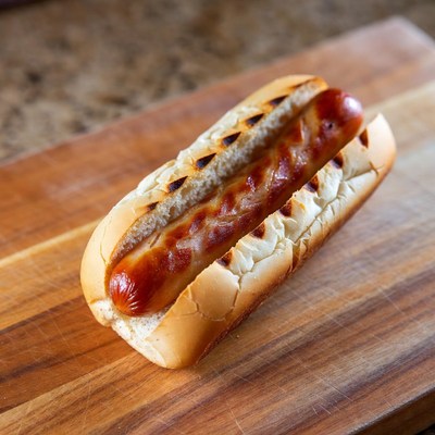 Grilled hot dog on wooden board