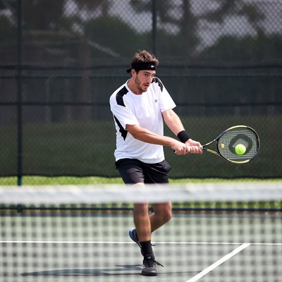 Man hitting tennis ball on court