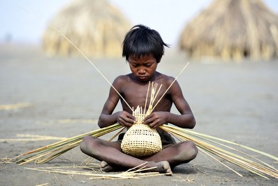 Young Asian boy weaving basket