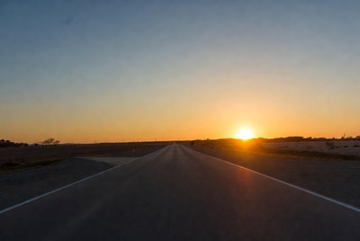 Sunset over rural straight road
