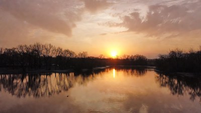 Sunset over reflective lake with trees
