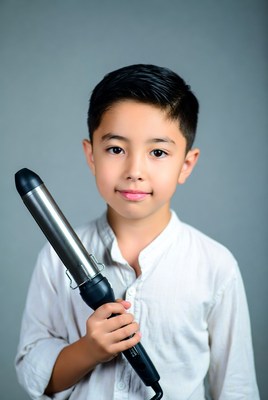 Asian boy holding curling iron