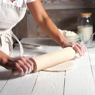 Woman rolling dough with rolling pin