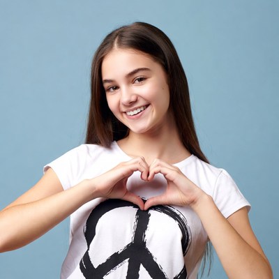Girl making heart hands with peace sign shirt
