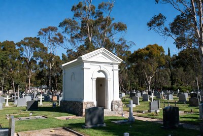 White Mausoleum in Cemetery with Graves