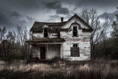 Abandoned haunted house in stormy field