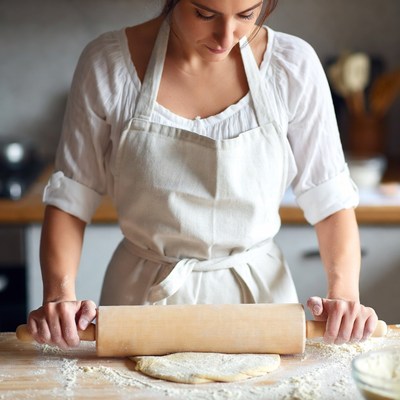 Woman rolling dough with rolling pin