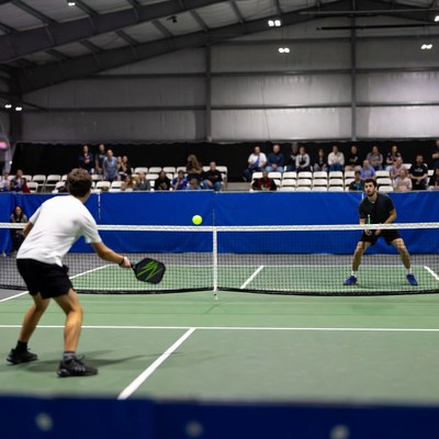 Two men playing pickleball indoors