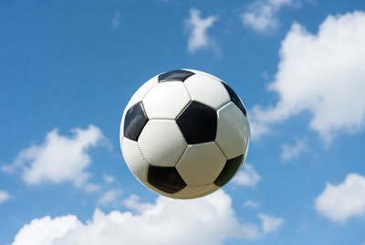 Soccer Ball Flying in Blue Sky