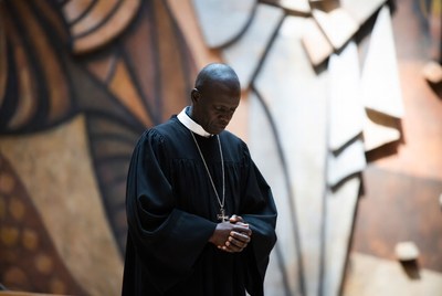 African priest praying with clasped hands