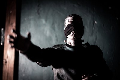 Blindfolded man reaching out door