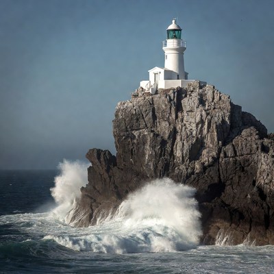 White Lighthouse on Rocky Cliff with Crashing Waves