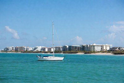 White Sailboat in Turquoise Water Near Beachfront Condos