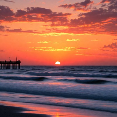 Sunset over pier and ocean waves