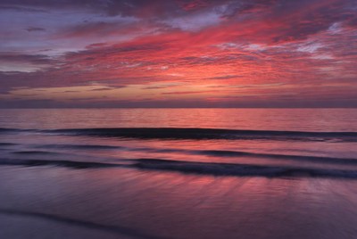 Vibrant Red Sunset Over Ocean Waves