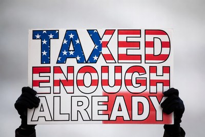 Hands holding 'Taxed Enough Already' sign