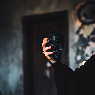 Woman holding black skull mask