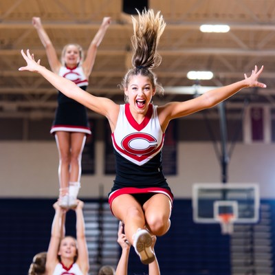 Cheerleader jumping with team