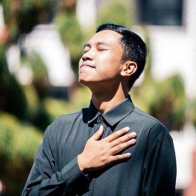 Asian man hand on heart outdoors