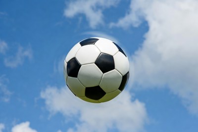 Soccer Ball Flying in Blue Sky