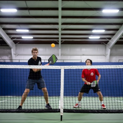 Two men playing pickleball across net