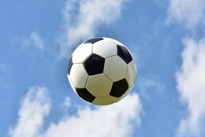 Soccer Ball Flying in Blue Sky