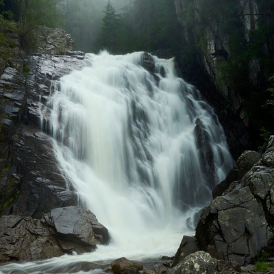 Waterfall cascading in misty forest