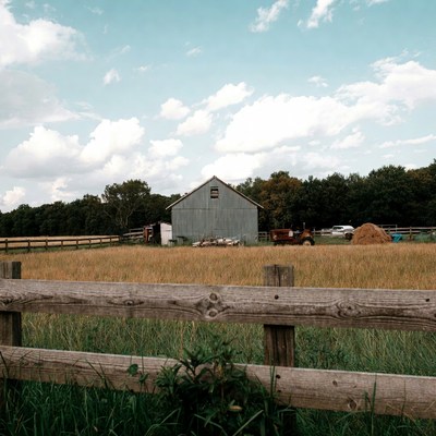 Rustic Barn and Red Tractor in Field