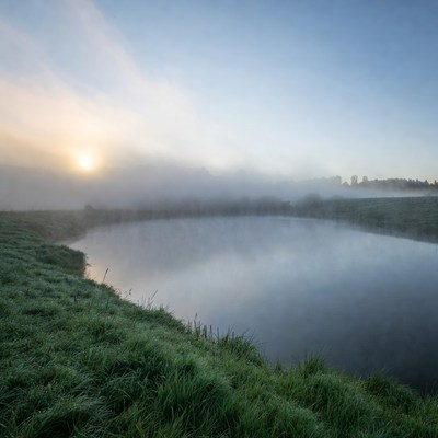 Sunrise over misty pond