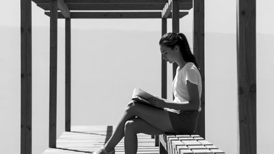 Woman reading book on pier