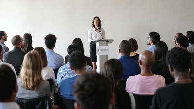 Woman speaking at podium to audience