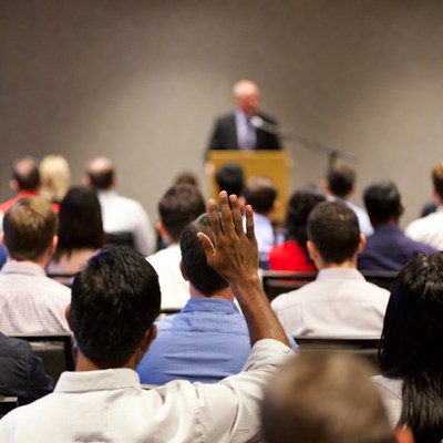 Man raising hand in classroom audience