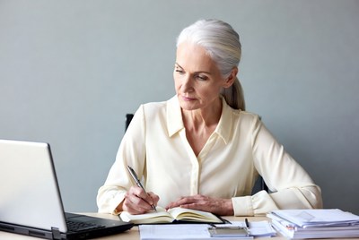 Elderly woman writing at desk