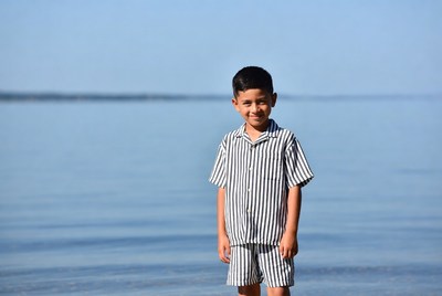 Young boy in striped pajamas by lake