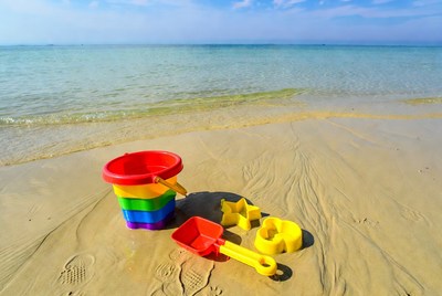 Colorful beach toys on sandy shore