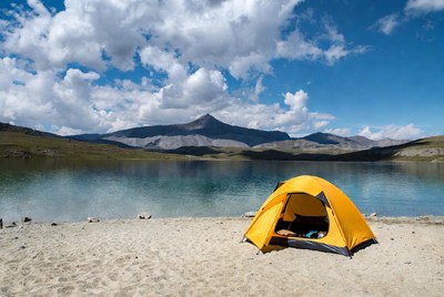 Yellow tent by mountain lake