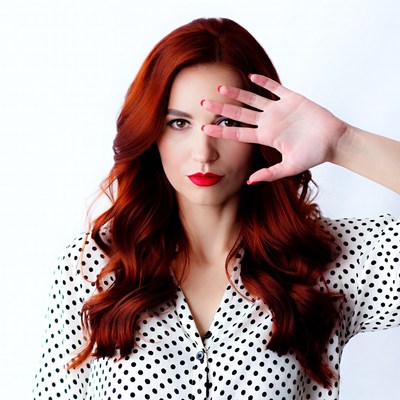 Redhead woman covering eye with hand